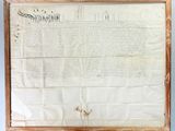 an old document with writing on it hanging on a wall