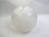 une image représentant une boule de verre blanche posée sur une surface blanche