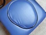 a blue chair with a black seat and a black handle