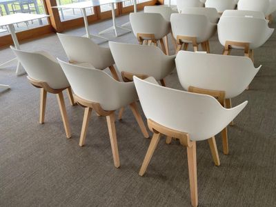 many white chairs in a large room with a balcony in the background