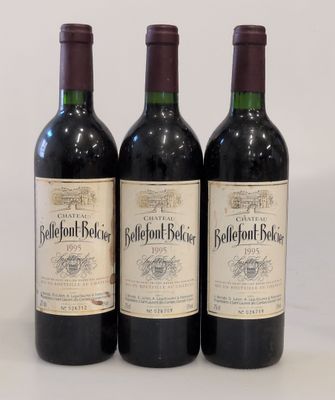 trois bouteilles de vin rouge posées sur une table blanche