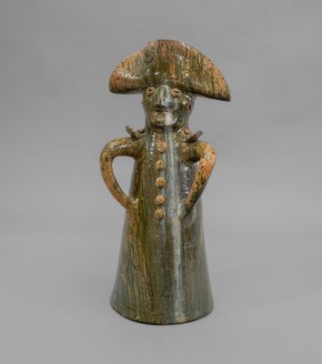une image représentant une figurine en céramique d'un homme portant un chapeau
