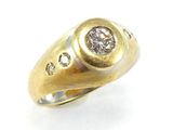 gros plan d'une bague en or avec un diamant au centre