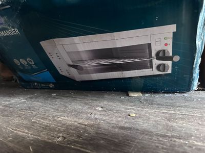 a box with a toaster oven inside of it on the floor