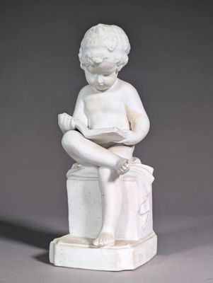 a white statue of a boy reading a book