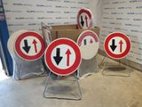 many signs that are sitting on the ground in front of a wall