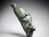 un gros plan d'un objet en bronze sur lequel figure un visage