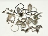a pile of silver jewelry on a white surface