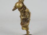 brass figurine of a man with a bag on his back