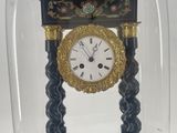 a clock under a glass dome on a table
