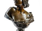 une image représentant un petit buste en bronze d'une femme sur fond blanc