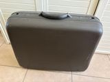 a gray suitcase sitting on the floor in a room