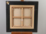 an old wooden easel with a black frame and a white background