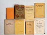 Plusieurs livres sont disposés sur une surface blanche, avec des couvertures orange.