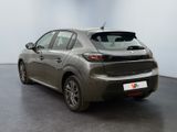 the back of a grey car in a room with a white wall