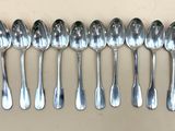 six cuillères en argent alignées en rang sur une table