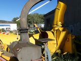 a machine that is sitting in the grass by a building