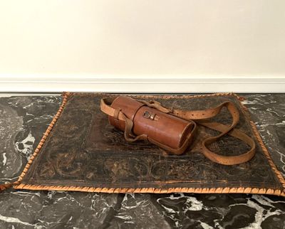 a brown leather bag on a black and white marble floor