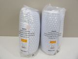 two bags of toilet paper sitting on a counter