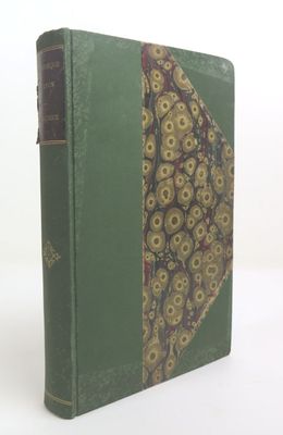 un vieux livre à la couverture verte ornée d'un motif