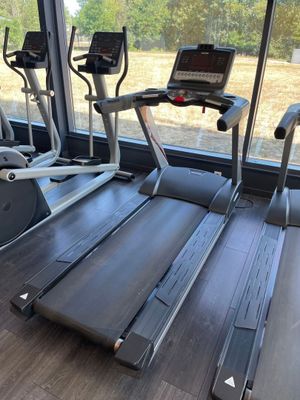 deux appareils de cardio dans la salle de sport avec vue sur le terrain