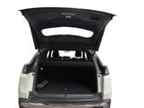 the back end of a white suv with its trunk open