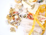 a bottle of perfume surrounded by a bunch of jewelry
