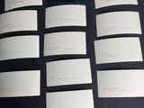 a lot of cards on a table with a piece of paper next to them