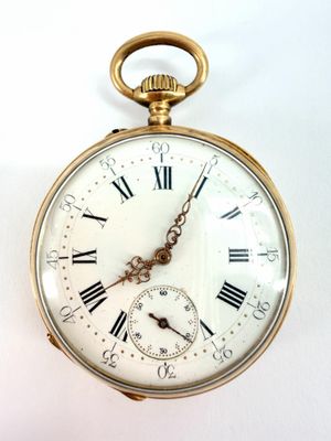 une montre de poche en or avec des chiffres romains sur le cadran