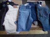 plusieurs paires de jeans posées sur une boîte en carton