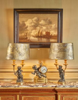 deux lampes posées sur une table, avec un tableau en arrière-plan
