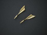 two gold tone hair clips on a black surface