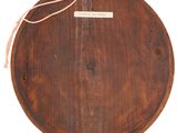 an old wooden plate with a tag on it sitting on a table