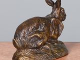 statue of a rabbit sitting on a rock on a table