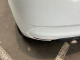 a white car parked in a parking lot next to a building