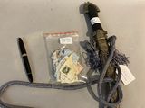 a black umbrella with a rope and a pen next to it