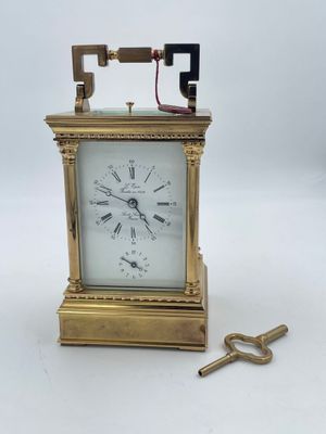 une vieille horloge en laiton surmontée d'une clé