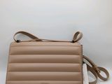 un sac à main en cuir beige muni d'une bandoulière et d'une étiquette blanche