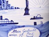 a blue and white plate with a picture of a statue of liberty