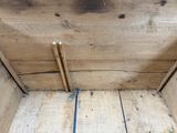 une boîte en bois avec une poignée bleue posée par terre