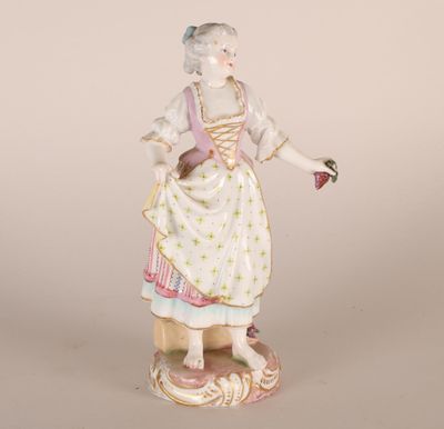 une figurine ancienne représentant une femme tenant une fleur à la main