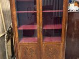 un meuble en bois avec des portes en verre dans une pièce