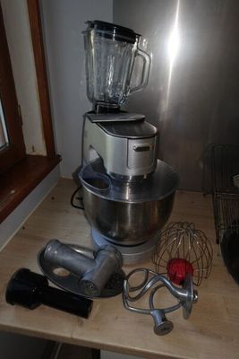 un mixeur posé sur une table en bois près d'une fenêtre