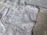 two pieces of white clothing on a bed with a white blanket