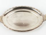 un plat ancien en argent avec des poignées, sur fond blanc