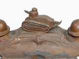 a bronze statue of a tank with two helmets on it