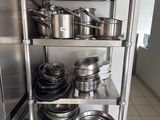 many pots and pans on the shelves in the kitchen