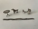 three pieces of silver jewelry including a horse drawn carriage, a bracelet, and a bracelet