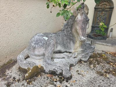 une statue représentant un cheval assis par terre