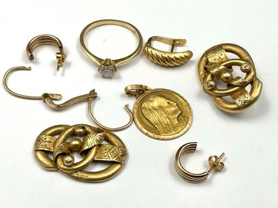 several pieces of gold jewelry are arranged on a white surface